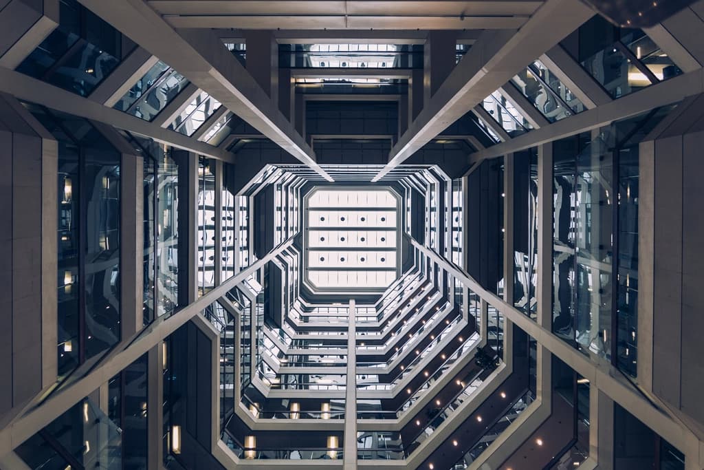 The atrium of a modern building seen through its lit ceiling